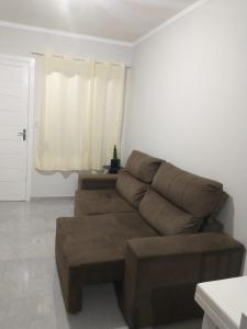 Venâncio AiresResidencial Adventus II的客厅里设有一张棕色沙发,配有窗户