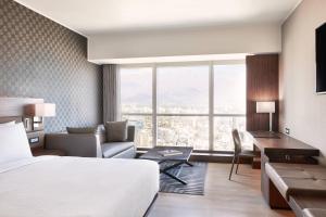 圣地亚哥AC Hotel by Marriott Santiago Costanera Center的酒店客房配有一张床、一张沙发和一张书桌。