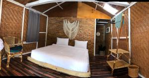 图克图克Hub Tata Guesthouse的卧室配有砖墙内的床铺