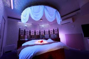 ホテル　モモ的紫色客房内的一间卧室,配有一张床