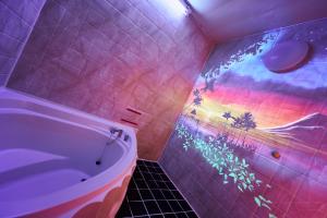 ホテル　モモ的浴室配有浴缸和墙上彩虹彩绘