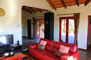 帕拉博鲁瓦Bushvilla Umoja Kruger的客厅配有红色沙发和电视