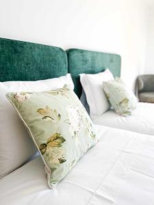 布拉干萨Apolo71 Alojamentos的一张白色的床,上面有花卉枕头
