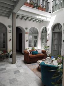 赫雷斯-德拉弗龙特拉La Gitanilla Alojamiento & Encanto Jerez的客厅配有沙发和桌子