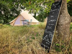 代因泽Tent 't Schaaphof的树旁的粉笔牌,带帐篷