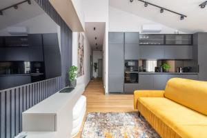 里加Luxurious penthouse with parking的一间带黄色沙发的客厅和一间厨房