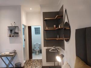 比勒陀利亚Lydiana Guesthouse的客房设有带卫生间和架子的浴室。