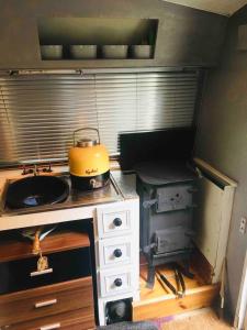 坎特伯雷little vintage caravan with cosy log burner的厨房配有带锅子的炉灶