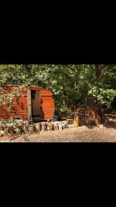 坎特伯雷little vintage caravan with cosy log burner的坐在田野顶上的橙色拖车