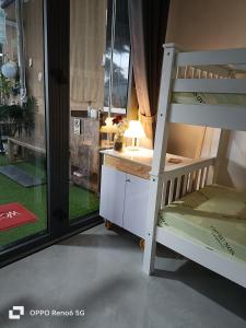 Cu ChiHOMESTAY -NHÀ MẸ KHANG的一间卧室配有双层床、书桌和窗户。