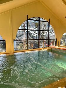 格拉玛多Chocoland Hotel Gramado soft opening的一座带大窗户的游泳池