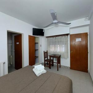 内乌肯Posada del Angel的一间卧室配有一张带吊扇和一张桌子的床。