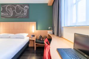 德帕内宜必思德帕酒店的酒店客房配有一张床铺和一张书桌上的笔记本电脑