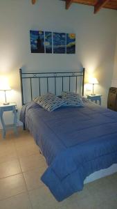 本塔纳山村Cabañas Lemunko的一间卧室配有一张蓝色的床和两张桌子