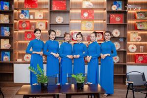 广义Khách sạn Lavie Hotel Quảng Ngãi的一群身着蓝色制服的女人站在架子前