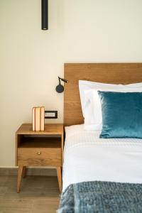 塞沃塔EPHYRA的一间卧室配有一张床和一个带蓝色枕头的床头柜