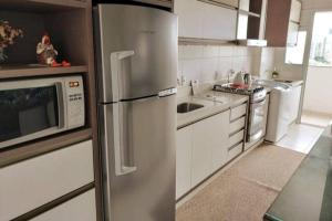 克里西玛Apto Centro de Criciúma的厨房配有不锈钢冰箱和微波炉。