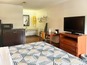 代顿Suites Dayton OH Englewood的一间卧室配有一张床和一台平面电视