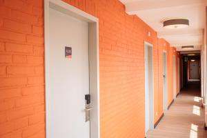 锡塔德The Tower Sportshostel的走廊上有一个开放式的门,有橙色砖墙