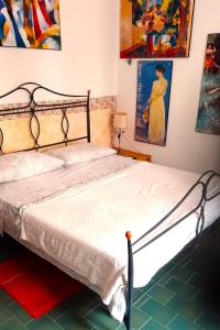 维罗纳Cozy!! Verona的卧室内的一张床铺,墙上挂有绘画作品
