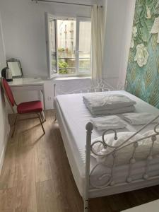 巴黎Ciel de Paris的一间卧室配有一张床、一张书桌和一个窗户。