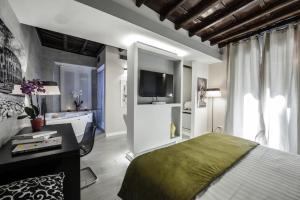 罗马Town House Spagna- luxury Rooms with Jacuzzi Bath的一间卧室配有一张床、一张书桌和一台电视