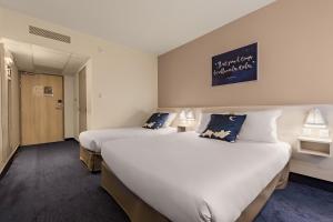 克莱蒙费朗艾斯酒店的酒店客房设有两张床,墙上有标志