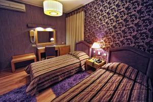 卡拉马塔Haikos Hotel的酒店客房,设有两张床和镜子