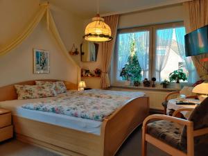 施内沃丁根Landhaus Heide的一间卧室配有一张床,窗户上有一棵圣诞树