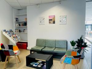 雷恩Hostel Rennes HI的客厅配有绿色沙发和椅子