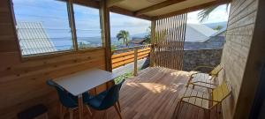 圣保罗Bungalow de Coco的木制甲板上配有桌椅的阳台