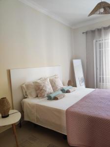 珀彻斯Casa Brisa do Mar的白色卧室配有床和桌子