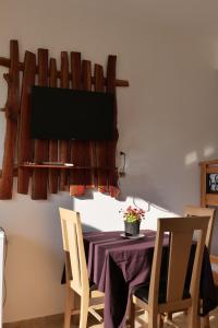 萨兰达Tropikal Freskia Bunec的一间设有桌子和墙上电视的用餐室
