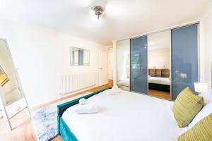 伦敦The Queensborough Apartments by Hyde Park的卧室设有白色大床和玻璃墙