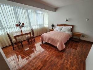 塔克纳Hotel Oceano Mit的一间卧室配有一张床和一张桌子,桌子上配有四柱床。