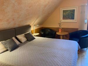 EltenFerienwohnung auf dem Eltenberg的一间卧室配有一张带两个枕头和两把椅子的床