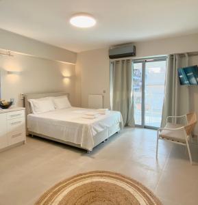 雅典Cottage Boutique Apartments Athens的一间带白色床的卧室和一个阳台