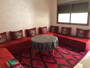 杰迪代Appartement à elJadida Bienvenue的客厅配有红色沙发及桌子