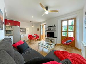 蓬特拉雷纳Apartamentos Puente La Reina的客厅配有灰色的沙发和红色的椅子