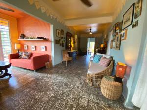 别克斯Casa de Amistad Guesthouse的客厅配有红色的沙发和椅子