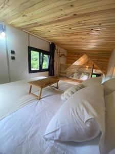 ArdeşenButka tiny house的一张白色大床,位于一个拥有木制天花板的房间