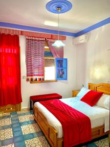 舍夫沙万Hôtel Al Kalaa的一间卧室配有床和红色窗帘