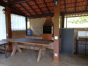 新弗里堡Casa com churrasqueira piscina privativa em São Pedro da Serra - Perto de Lumiar的厨房配有木桌和砖炉
