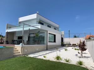格罗韦Casa Leiras的白色的房子,设有玻璃窗和院子