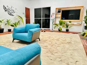 马富施Pelican Beach Maafushi的客厅配有蓝色椅子和电视