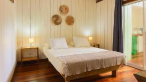 卡维塔拉纳卡维塔山林小屋的一间卧室配有一张带两张桌子和两盏灯的床。