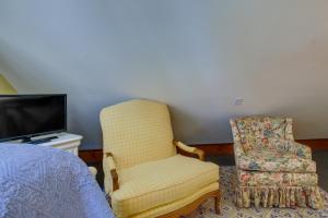WashingtonRomantic Cottage in Washington Historic District的一间卧室配有一张床、一把椅子和电视。