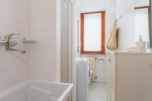 奥里斯塔诺Casa Grazia的白色的浴室设有浴缸和水槽。
