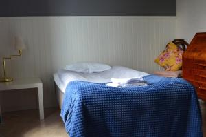 哈诺桑德Sörgårdens Logi的小卧室配有一张带蓝色毯子的床