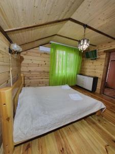 SzackБаза відпочинку Діана的木制客房内的一间卧室,配有一张床